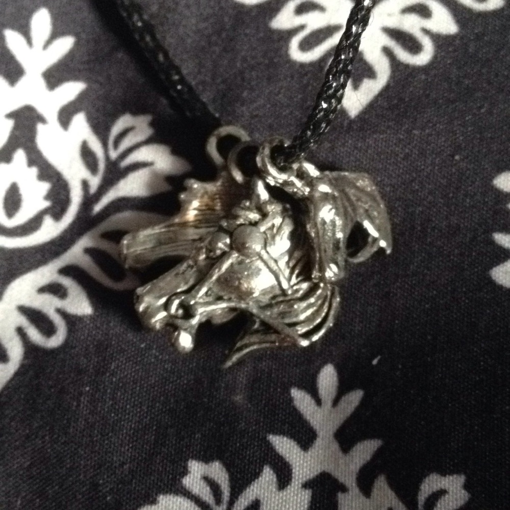 A black cord necklace with 3 horse charms
